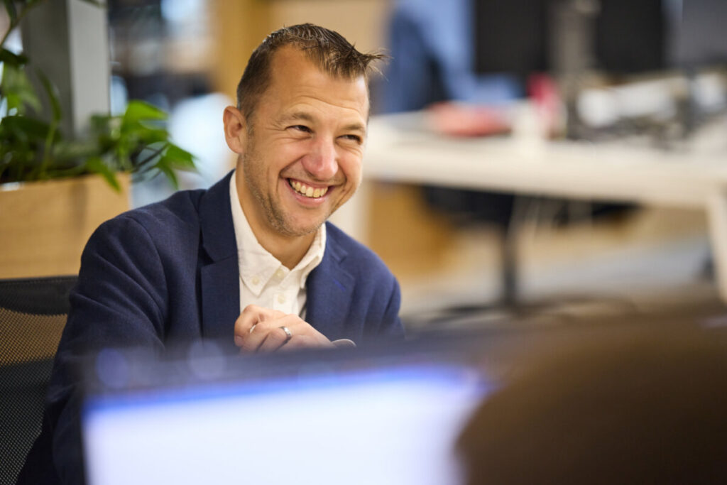 James Fieldhouse laughing at his desk